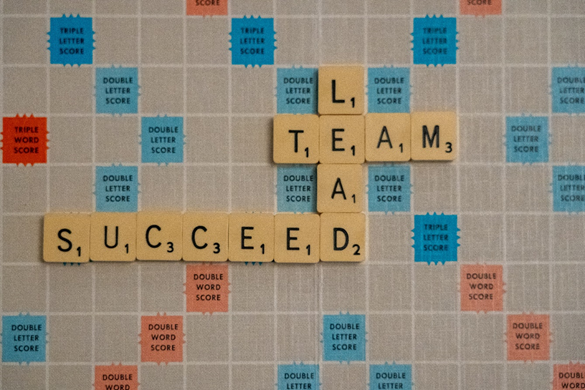 A scrabble board with the words “Team”, “Lead” and “Succeed” spelled out